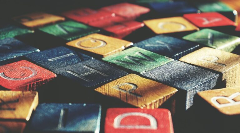 Vintage-style close-up of colorful wooden alphabet blocks creating an artistic pattern.