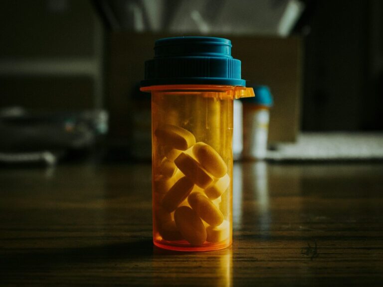 a bottle filled with pills sitting on top of a wooden table